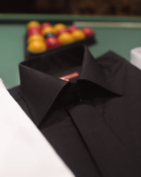 Black Colin Ross formal shirt displayed on a hanger, showcasing its sleek, plain design and classic collar for elegant dressing.