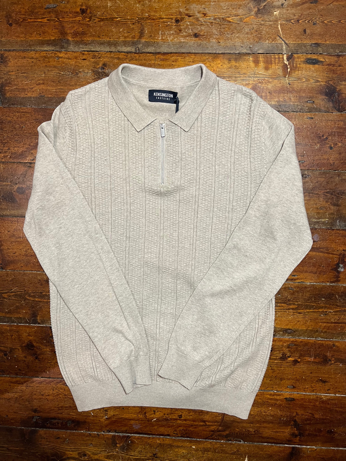 Long sleeve beige Bowditch half zip polo shirt with a classic collar and subtle branding, displayed on a neutral background.